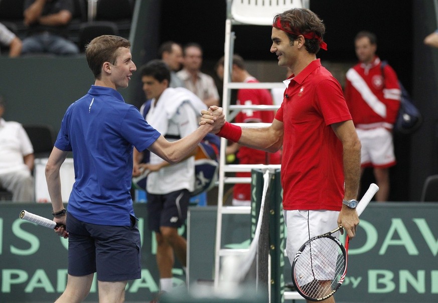 Swiss Davis Cup tennis player Roger Federer, right, shakes hands with Simon Ammann, Swiss ski jumping Olympic Champion, after a short training session in the Postfinance Arena in Bern, Switzerland, Th ...