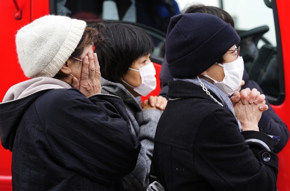 epa11057803 Local residents react as rescue workers carry out an operation at a collapsed house following an earthquake in Wajima, Ishikawa Prefecture, Japan, 05 January 2024. At least 82 people were  ...