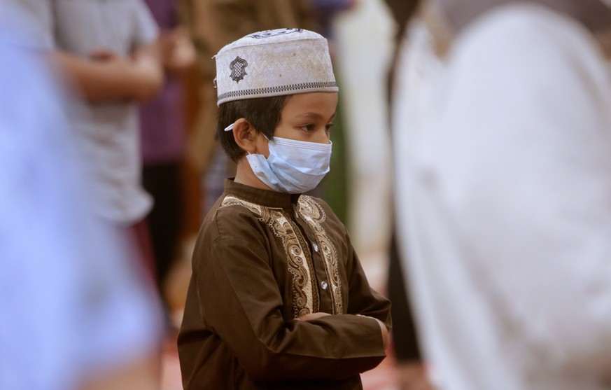 epa09130834 An Indonesian muslim boy prays during first Taraweeh prayers on the eve of Ramadan at a mosque in Depok, Indonesia, 12 April 2021. It���s a month of gratitude in which the faithful are rem ...