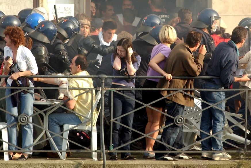 JAHRESRUECKBLICK 2003 - INLAND - G8-GIPFEL IN EVIAN - AUSSCHREITUNGEN IN GENF: Police officers try to follow rioters escaping over the terrasse of a restaurant in downtown Geneva, Sunday, June 1, 2003 ...