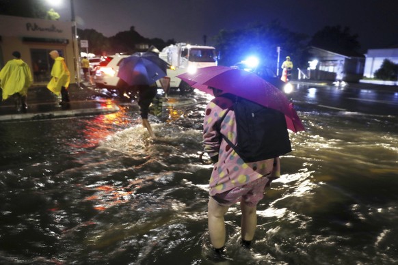 People cross a flooded street in Auckland, Friday, Jan. 27, 2023. Record levels of rainfall pounded New Zealand&#039;s largest city, causing widespread disruption. (Dean Purcell/New Zealand Herald via ...