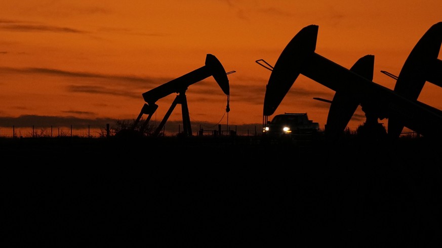 File - A truck passes oil pump jacks at dusk near Karnes City, Texas, Nov. 1, 2023. On Wednesday, the Labor Department releases producer prices data for November. The producer price index is an indica ...