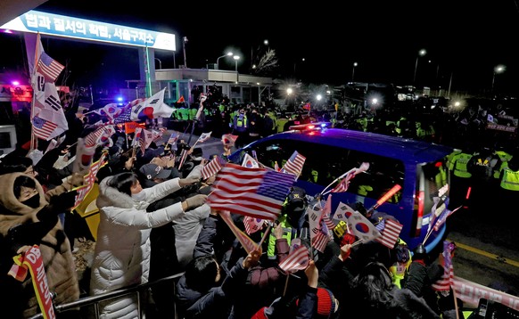 epa11833739 Supporters of impeached South Korean President Yoon Suk Yeol cheer for him as convoy believed to be carrying Yoon returns him to the Seoul Detention Center in Uiwang, just south of the cap ...