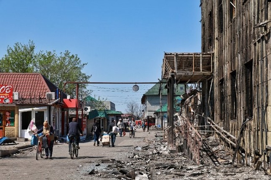 La ville de Pokrovsk détruite par les bombardements russes. Des personnes passent devant des magasins endommagés par les bombardements russes.