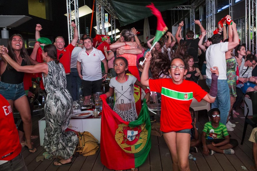 French and Portuguese supporters soccer watch the game on a giant TV screen during the final match between France and Portugal to the UEFA EURO 2016 football championship in France, late Sunday, July  ...