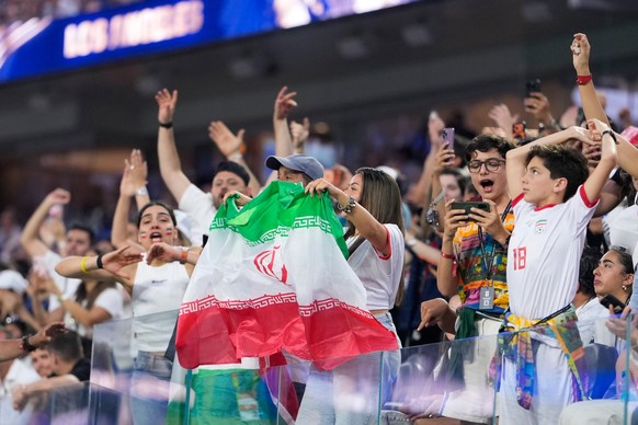 Fans celebrate and wave an Iranian flag during the World Cup Group G soccer match between Iran and New Zealand in Inglewood, Calif., near Los Angeles, Monday, June 15, 2026. (AP Photo/Mark J. Terrill)