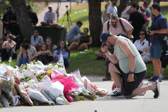 A man kneels after laying flowers at a memorial outside the Bondi Pavilion at Sydney's Bondi Beach, Monday, Dec. 15, 2025, a day after a shooting. (AP Photo/Mark Baker)
Australia Shooting