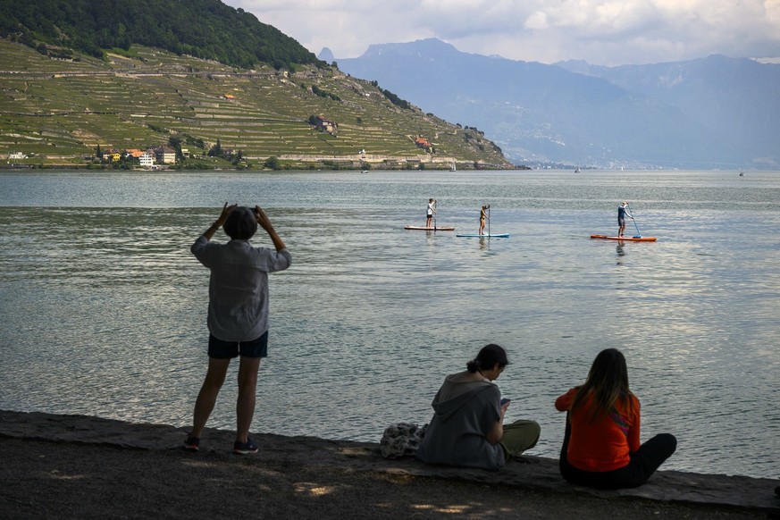 Des personnes font du paddle et du bateau sur le lac Leman lors d&#039;une journee ensoleillee devant le vignoble en terrasses de Lavaux le dimanche 28 mai 2023 a Cully. (KEYSTONE/Jean-Christophe Bott ...