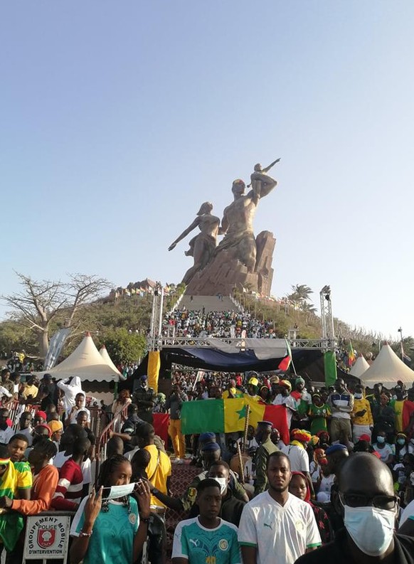 La foule attend l'arrivée des joueurs sénégalais devant le monument de la renaissance africaine à Dakar.