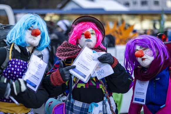 Three people dressed as a clowns perform as they attend a demonstration of the collective &#039;Strike WEF&#039; before the annual meeting of the World Economic Forum, WEF, in Kueblis, Switzerland, on ...
