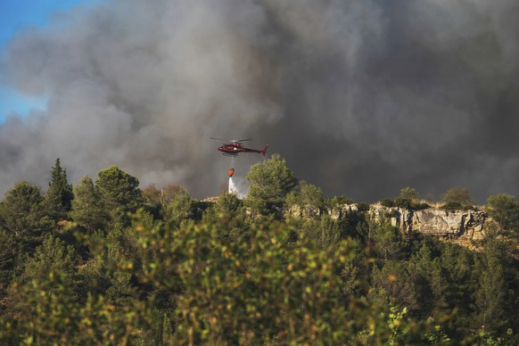 An helicopter drops water on a fast-moving wildfire in a Mediterranean region of France near the Spanish border is pictured Tuesday Aug.5, 2025. (Richard Capoulade/UGC via AP)
France Fires