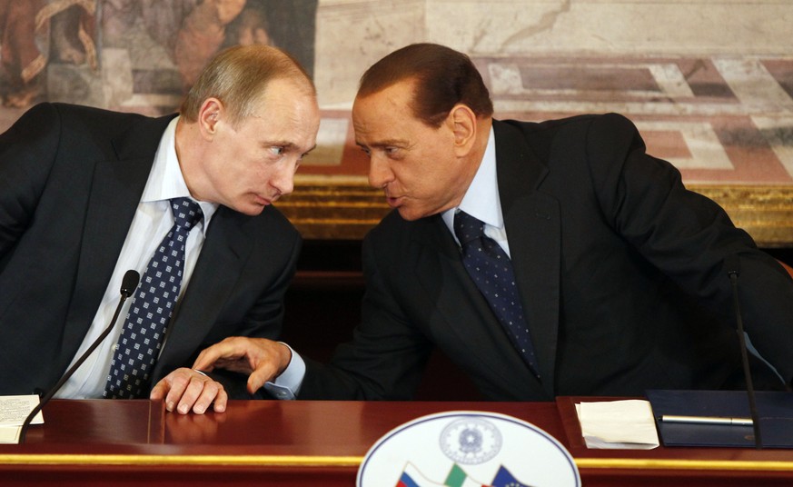 Sur cette photo d&#039;archives du 26 avril 2010, l&#039;ex-président du Conseil italien, Silvio Berlusconi, à droite, et le président russe Vladimir Poutine discutent lors d&#039;une conférence de pr ...