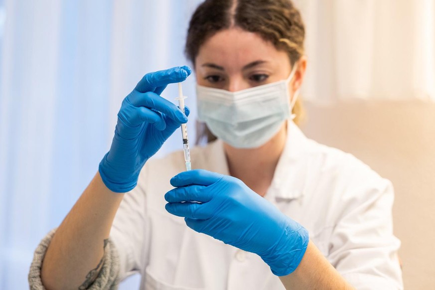 Une femme prepare une seringue du vaccin Pfizer-BioNTech dans les locaux de la Fondation Pre Pariset (Etablissements Medico-Sociaux, EMS) avant qu&#039;une equipe mobile de vaccination de la protectio ...