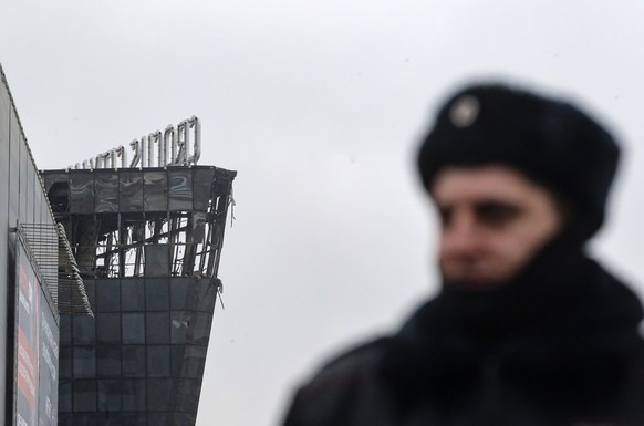 epa11238307 A Russian policeman guards near the burned Crocus City Hall concert venue following a terrorist attack in Krasnogorsk, outside Moscow, Russia, 23 March 2024. On 22 March evening, a group o ...