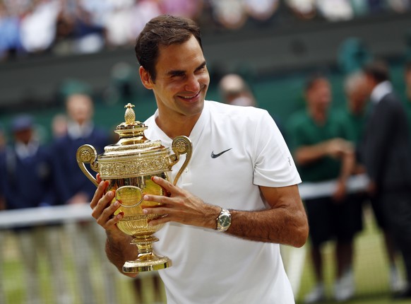 epa10185697 (FILE) - Roger Federer of Switzerland holds the championship trophy following his victory over Marin Cilic of Croatia in the men&#039;s final of the Wimbledon Championships at the All Engl ...