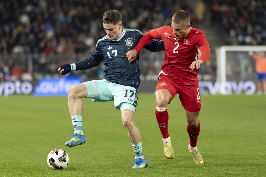 Germany's Florian Wirtz, left, fights for the ball against Switzerland's Miro Muheim, right, during a friendly soccer match between Switzerland and Germany at the St. Jakob-Park stadium in B ...