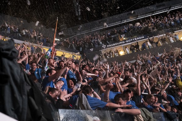 Les supporters fribourgeois celebrent la victoire de leur equipe apres prolongation (3-2) lors de la diffusion du septieme match de la finale des play-off du championnat suisse de hockey sur glace de  ...