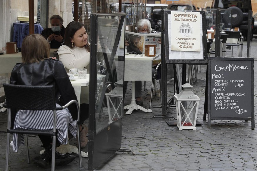 People enjoy a hot drink at an outdoor seating area of a caf