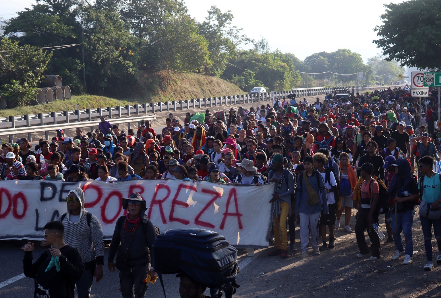 epa11044999 Migrants walk in a caravan heading to the northern border with the US, in the municipality of Huixtla in Chiapas, Mexico, on 26 December 2023. A caravan of more than 6,000 migrants is adva ...