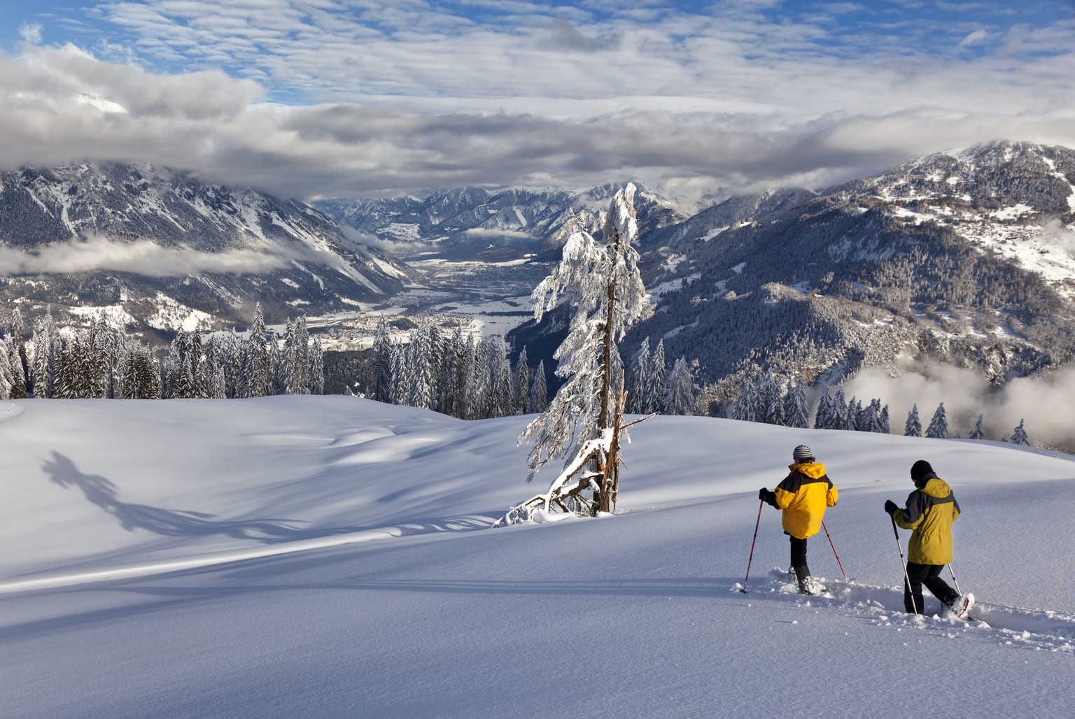 Two persons on snow shoes enjoy the wonderful winter weather during their tour, on the Alp Sut, above Bonaduz, with a view on the city of Chur, Switzerland, Tuesday, January 10, 2012. (KEYSTONE/Arno B ...