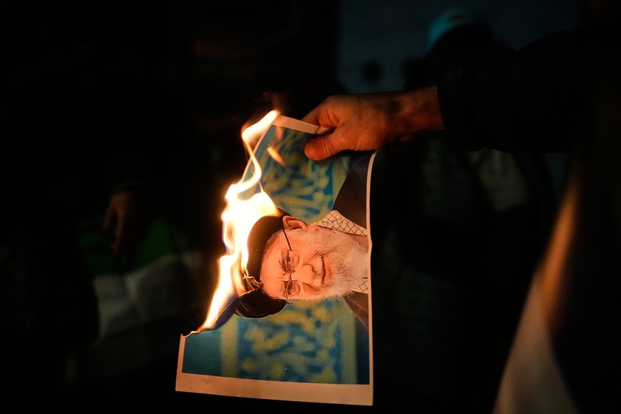 Demonstrators burn a poster depicting Iran's Supreme Leader Ayatollah Ali Khamenei during a rally in support of anti-government protests in Iran, in Holon, Israel Wednesday, Jan. 14, 2026. (AP Ph ...