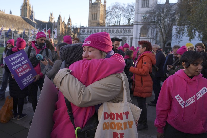 Protesters react in front of Parliament in London, Friday, Nov. 29, 2024 as British lawmakers have given initial approval to a bill that would help terminally ill adults to end their lives in England ...