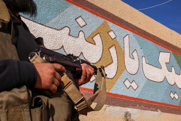 epa11754245 A member of the Syrian opposition stands at a military position allegedly used by Iranian forces after it was captured by the Syrian opposition in the city of Khan Sheikhoun, Idlib country ...