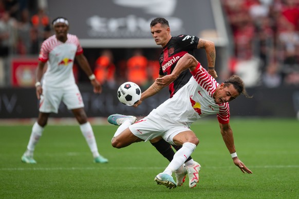 19.08.2023, Nordrhein-Westfalen, Leverkusen: Fu�ball: Bundesliga, Bayer Leverkusen - RB Leipzig, 1. Spieltag, BayArena. Leverkusens Granit Xhaka (l) und Leipzigs Yussuf Poulsen k�mpfen um den Ball. Fo ...