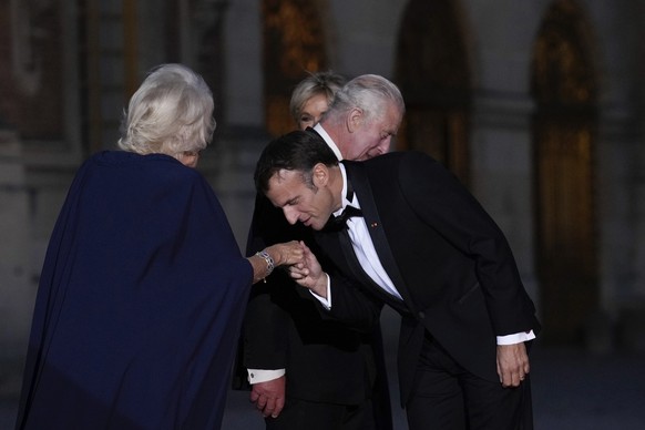 French President Emmanuel Macron, right, his wife Brigitte Macron, left, Britain's King Charles III, second from right, and Queen Camilla arrive for a state dinner, at the Chateau de Versailles, ...