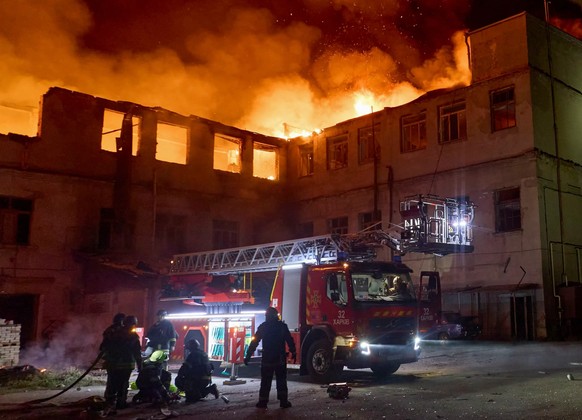 Des pompiers ukrainiens après une nouvelle attaque aérienne de grande ampleur sur Kharkiv (est).