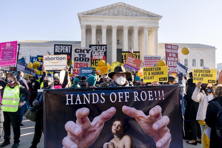 FILE - Stephen Parlato of Boulder, Colo., holds a sign that reads &quot;Hands Off Roe!!!&quot; as abortion rights advocates and anti-abortion protesters demonstrate in front of the U.S. Supreme Court, ...