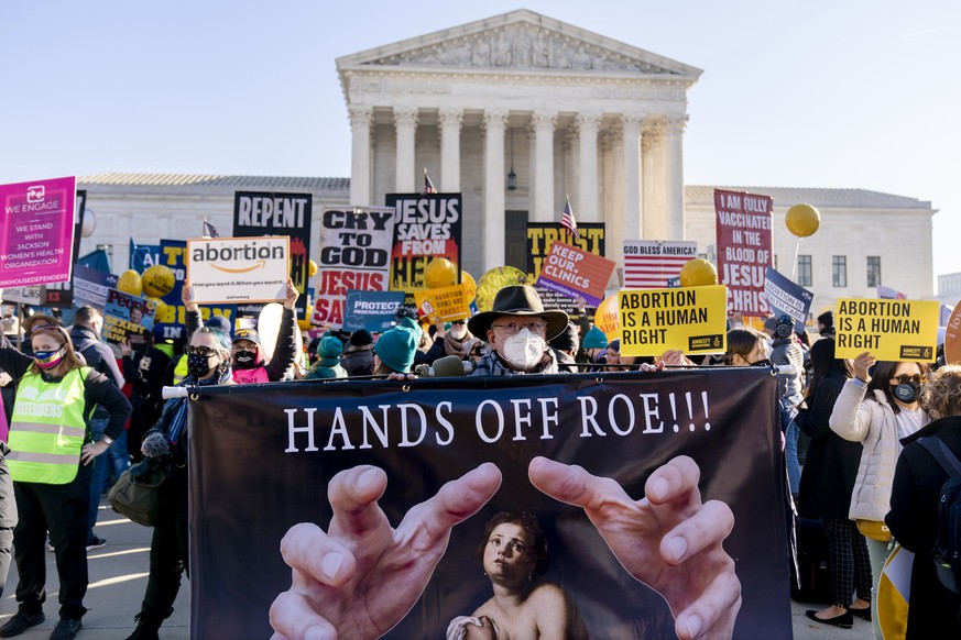 FILE - Stephen Parlato of Boulder, Colo., holds a sign that reads "Hands Off Roe!!!" as abortion rights advocates and anti-abortion protesters demonstrate in front of the U.S. Supreme Court, ...