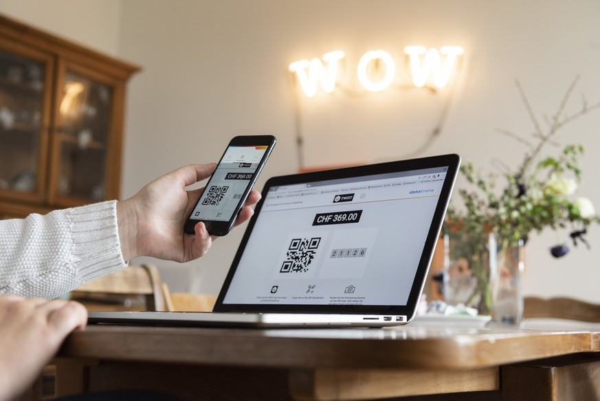 [Staged Picture] A person does online shopping on a laptop by using the Twint payment app on a smartphone, photographed in Bern, Switzerland, on May 2, 2018. (KEYSTONE/Christian Beutler)