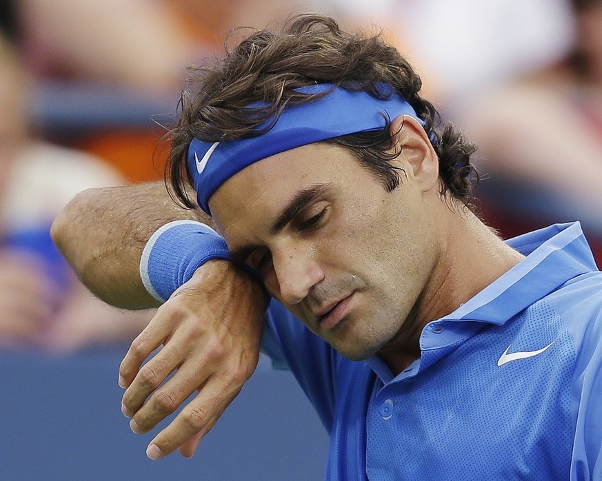 Roger Federer, of Switzerland, wipes sweat from his face between points during his match against Tommy Robredo, of Spain, during the fourth round of the 2013 U.S. Open tennis tournament, Monday, Sept. ...