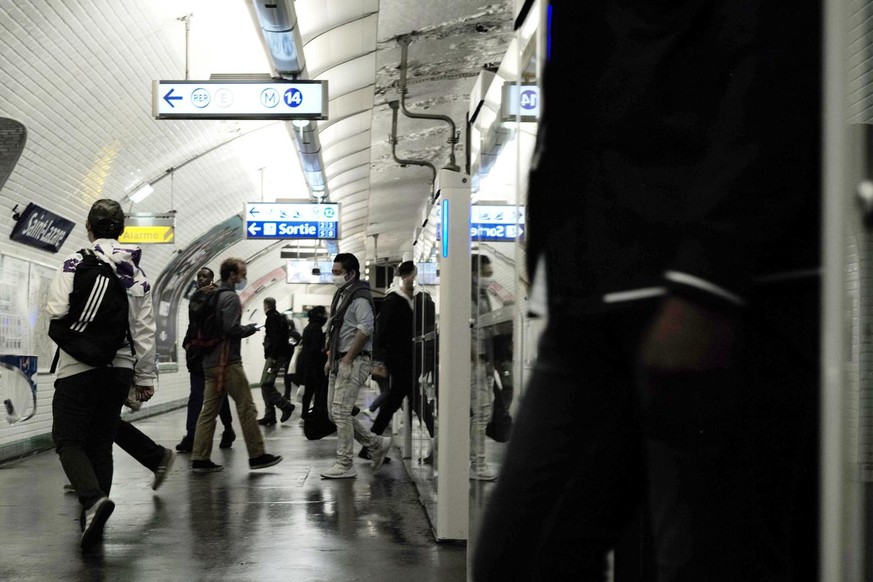 epa08400086 Commuters in protective face mask exit an underground train at a metro station in Paris, France, 04 May 2020. French government plans to loosen containment measures and traffic restriction ...