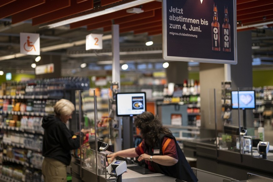 Plakate weisen auf die Abstimmung zum moeglichen Verkauf von alkoholischen Getraenken in der Migros hin, am Dienstag, 24. Mai 2022 in der Migros Filiale Lorraine in Bern. Anfang Juni 2022 koennen die  ...