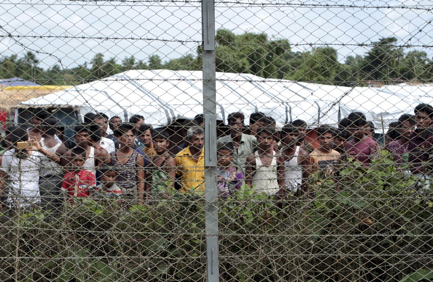 Des réfugiés rohingyas se rassemblent près d'une clôture lors d'une visite des médias organisée par le gouvernement, dans un no man's land entre le Myanmar et le Bangladesh.