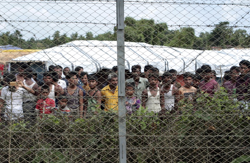 FILE - Rohingya refugees gather near a fence during a government organized media tour, to a no-man&#039;s land between Myanmar and Bangladesh, near Taungpyolatyar village, Maung Daw, northern Rakhine  ...