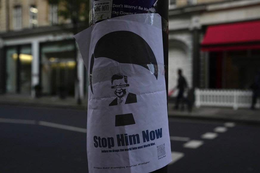 A placard featuring Chinese President Xi Jinping, is displayed near the Chinese embassy in London, Monday Nov. 28, 2022. Demonstrators gathered outside the Chinese embassy in London on Sunday night, i ...