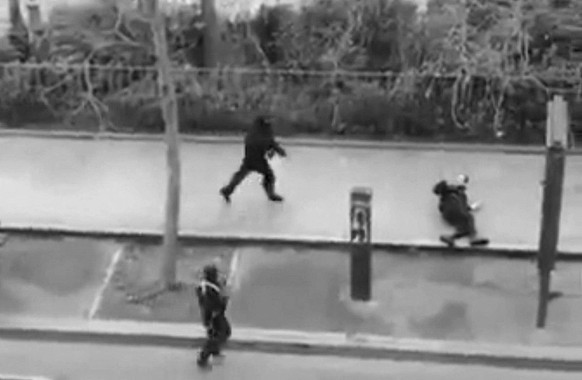 Masked gunman run towards a victim of their gun fire outside the French satirical newspaper Charlie Hebdo&#039;s office, in Paris, Wednesday, Jan. 7, 2015. Paris residents captured chilling video imag ...