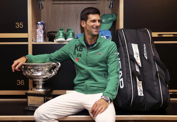 Novak Djokovic of Serbia poses with the Norman Brookes Challenge Cup in the locker room, Monday Feb. 3, 2020 after winning the men&#039;s singles final against Dominic Thiem of Austria at Australian O ...