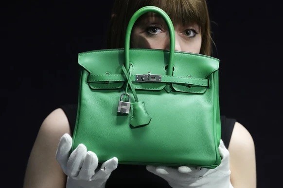 Une employée de Bonhams présente un sac Hermès : un Birkin 25 en cuir vert «Bambou Swift», dans les salles de vente de Londres, le lundi 26 février 2024. Ce sac, dont la valeur est estimée entre 12 00 ...