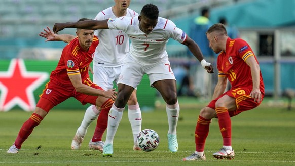 Switzerland&#039;s Breel Embolo, center, is caught between Wales&#039; Aaron Ramsey, left, and Wales&#039; Joe Morrell during the Euro 2020 soccer championship group A match between Wales and Switzerl ...