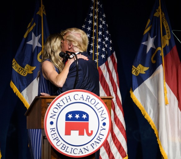 GREENVILLE, NC - JUNE 05: Former U.S. President Donald Trump kisses his daughter-in-law, Laura Trump, after she told the crowd she would not be running for the NC Senate at the NCGOP state convention  ...