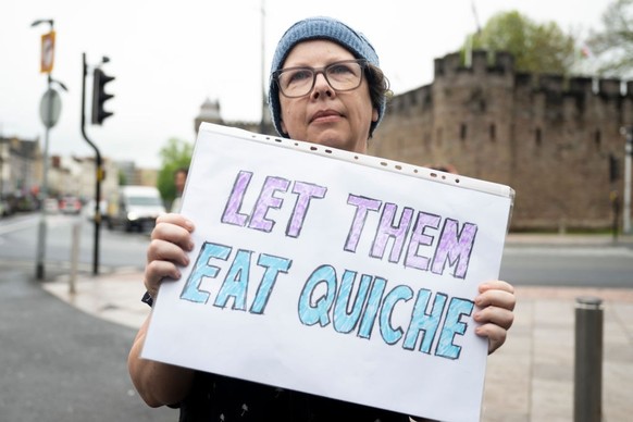 CARDIFF, WALES - MAY 6: A woman holds a sign saying &quot;let them eat quiche&quot; during a protest against the the Coronation of King Charles III and Queen Camilla on May 6, 2023 in Cardiff, Wales.  ...