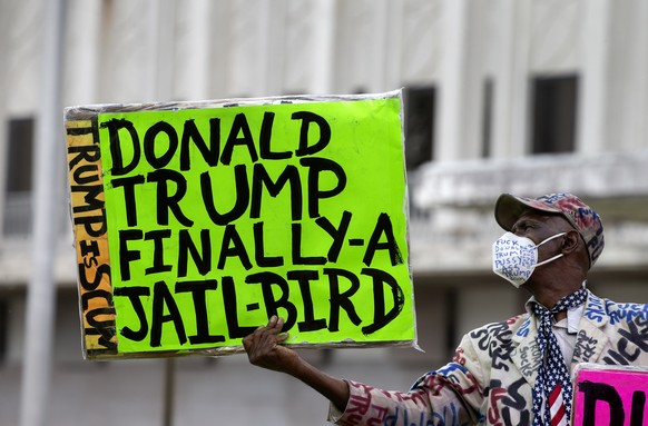 epa10128140 A person holds a placard in front of the Paul G. Rogers Federal Courthouse in West Palm Beach, Florida, USA, 18 August 2022. Magistrate Judge Bruce Reinhart told officials of the Departmen ...