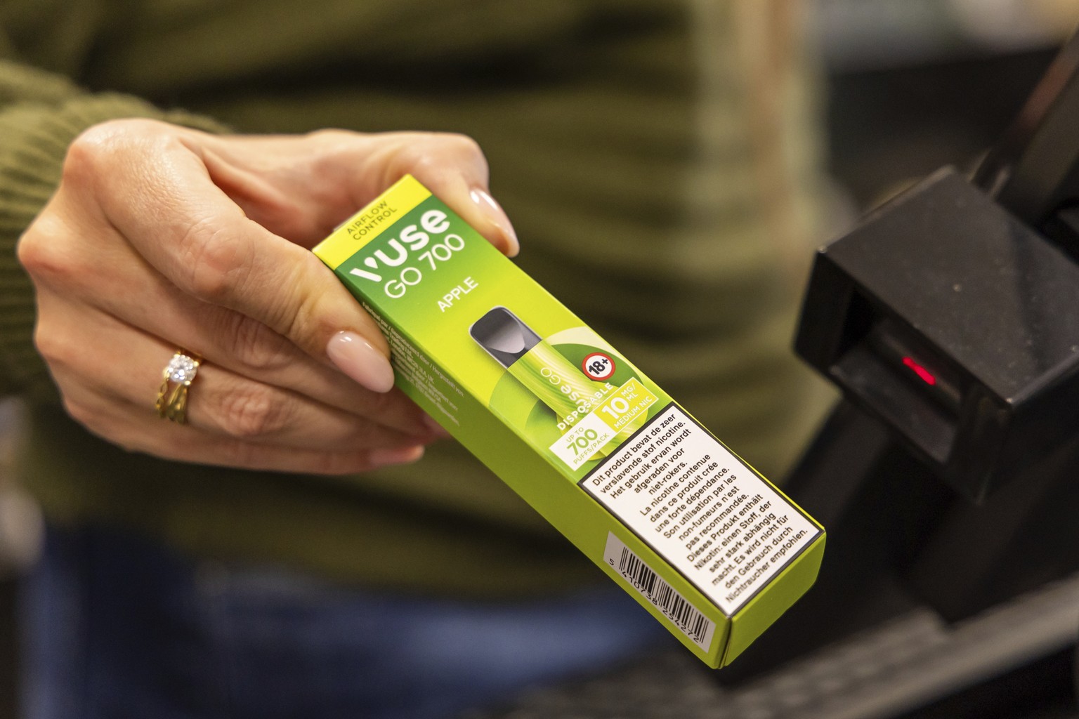 A storekeeper moves a disposable electronic cigarette device past a price scanner at a shop in Brussels on Dec. 12, 2024, ahead of Belgium&#039;s ban on the sale of disposable vapes as of Jan. 1, 2025 ...