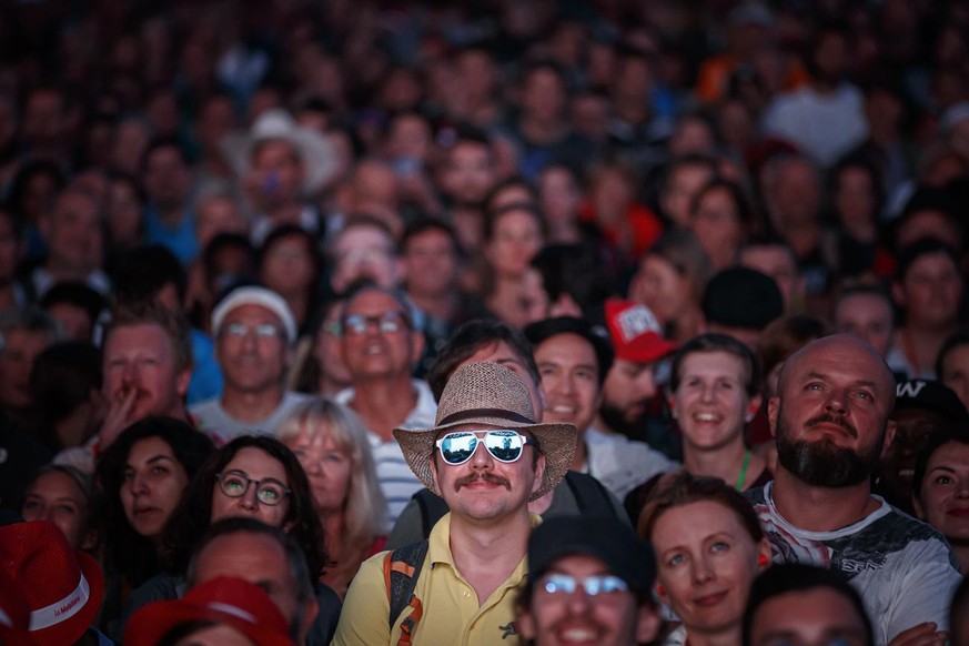 Festival goers watch Swiss humorists Vincent Kucholl and Vincent Veillon (not pictured) perform their show &quot;Le Fric&quot; on the main stage, during the 44th edition of the Paleo Festival, in Nyon ...