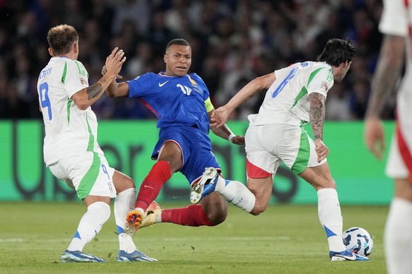 France&#039;s Kylian Mbappe, center, vies for the ball with Italy&#039;s Sandro Tonali and Mateo Retegui, left, during the UEFA Nations League soccer match between France and Italy at the Parc des Pri ...