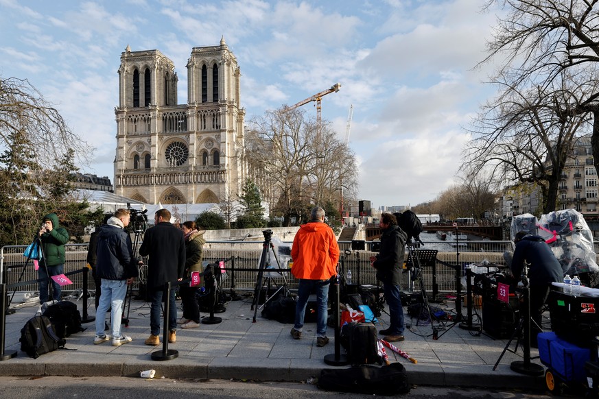 epa11762046 Journalists stand outside the Notre Dame de Paris cathedral, ahead of its official reopening ceremony, in Paris, France, 07 December 2024. The Notre Dame de Paris Cathedral reopens on 07 D ...